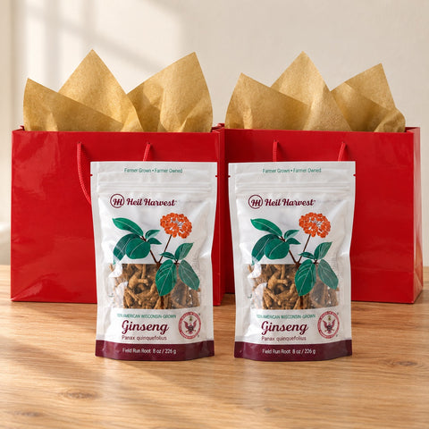 Two red gift bags with gold tissue and two 8 oz Heil Harvest 5-year ginseng pouches